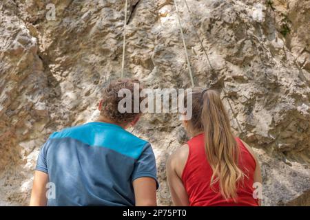 Männlicher Kletterlehrer, der den richtigen Weg zum erfolgreichen Klettern für weibliche Anfänger berät Stockfoto