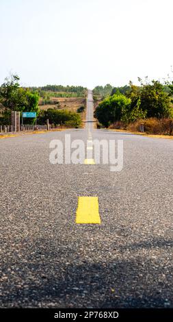 Foto zur Bestätigung des Ziels und des richtigen Weges. Nie Aufhören, Motivierend Zu Sein. Wunderschöne Aussicht auf die leere Asphaltstraße mit gelber Linie in der Berglandschaft Stockfoto