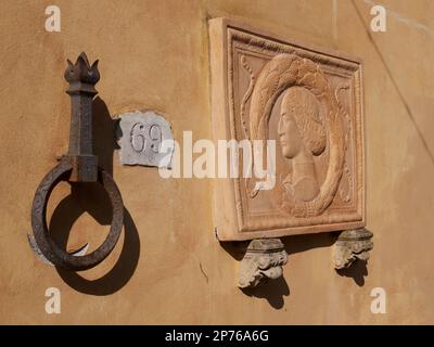 Eine dekorative Tafel, die im öffentlichen Park in Montecatini Terme an einer Wand befestigt ist, mit einem weiblichen Gesicht im Stil eines antiken römischen Kunstwerks Stockfoto