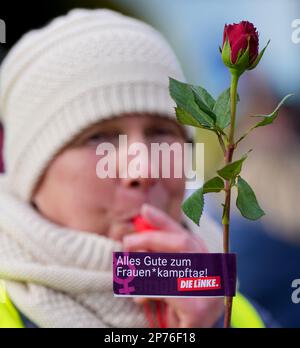 Hennigsdorf, Deutschland. 08. März 2023. Der Teilnehmer einer Demonstration zum Internationalen Frauentag hält eine Rose mit der Botschaft "Happy Women's* Right Day!". Kredit: Soeren Stache/dpa/Alamy Live News Stockfoto