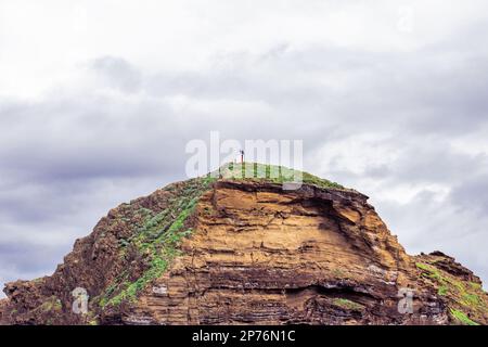 Ein Haus auf einem Berg mit Wolken darüber Stockfoto