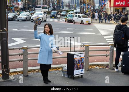 Zeugen Jehovas; Frau Verteilen von Kopien der Wachturm auf Straße Ecke, Shinjuku, Tokyo, Japan Stockfoto