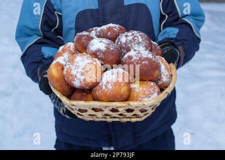 Köstlicher süßer Pampushka in den Händen des Jungen Stockfoto