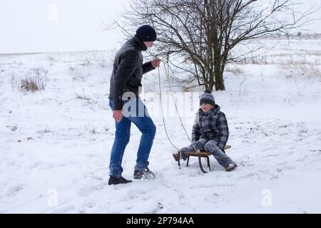 Glückliche Jungs, zwei Brüder, Schlitten im Winter Stockfoto