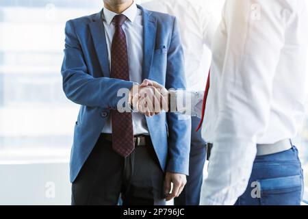Händedruck von zwei Geschäftspartnern, die im Büro bei einer Firmenbesprechung kommunizieren Stockfoto