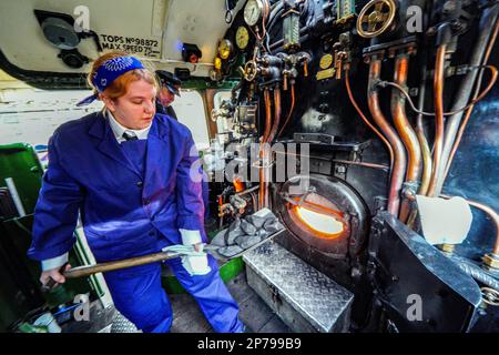 Steph Elwood, die zweite Frau, die Feuerwehrmann wurde, arbeitet an Bord der Flying Scotsman, die von einem ausschließlich weiblichen Fußplatten-Team zum Internationalen Frauentag bei der East Lancashire Railway in Bury, Greater Manchester, betrieben wird. Bilddatum: Mittwoch, 8. März 2023. Stockfoto