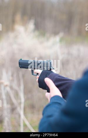 Junge weibliche Arme und Hände, die in der Selbstverteidigungstraining mit einer Handfeuerwaffe zielen, sind nicht wiederzuerkennen. Stockfoto