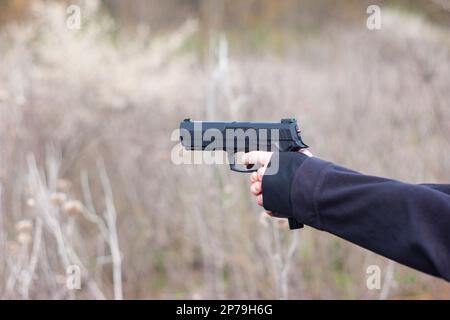 Junge weibliche Arme und Hände, die in der Selbstverteidigungstraining mit einer Handfeuerwaffe zielen, sind nicht wiederzuerkennen. Stockfoto