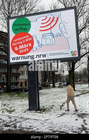 08. März 2023, Nordrhein-Westfalen, Düsseldorf: Im Vorfeld des landesweiten Warntages wird während einer Fotosession in der Düsseldorfer Innenstadt eine digitale Anzeigetafel angezeigt. Zum ersten Mal verwendet der Bundesstaat Nordrhein-Westfalen die 1100 Systeme eines deutschen Unternehmens für einen Testalarm am landesweiten Warntag am 09. März. Foto: Henning Kaiser/dpa Stockfoto