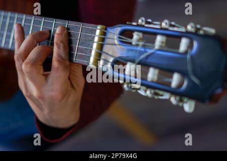 Nahaufnahme eines manns, der die spanische Gitarre selektiv spielt Stockfoto