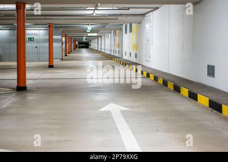 Leerer beleuchteter Tiefgaragenparkplatz großer Bereich Weitwinkelblick, keine Personen. Stockfoto