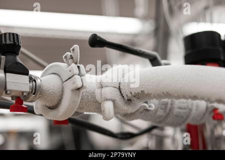 Flüssigstickstoff-gefrorener Wasserhahn und Metallrohre in einer Forschungseinrichtung, isolierte Nahaufnahme. Stockfoto