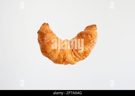 Ein einzelnes Croissant mit frischer Butter, Nahaufnahme eines Makro-Studios, isoliert auf Weiß. Stockfoto