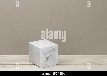 Steinernes Podium zur Beförderung auf beigem Hintergrund. Natürlicher Sockel. Eine Würfelform. Modell von Schönheitsprodukten. Szene, um Produkte anzuzeigen. Schaukasten, Schaukasten Stockfoto