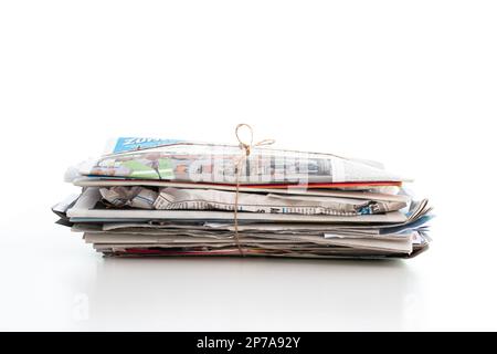 Gestapelter, gepresster und verpackter Hauspapiermüll, der für das Recycling abgeholt werden kann. Nahaufnahme Studio, isoliert auf Weiß, keine Leute. Stockfoto