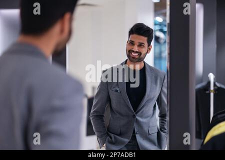 Junger Mann, der im Bekleidungsgeschäft einkauft Stockfoto