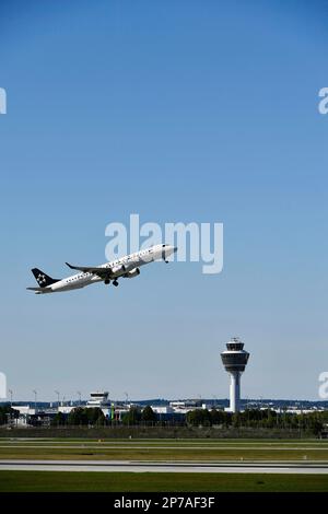 Start der Star Alliance AIR DOLOMITI EMBRAER ERJ-195 auf der Startbahn nach Süden mit Turm, Flughafen München, Oberbayern, Bayern, Deutschland Stockfoto