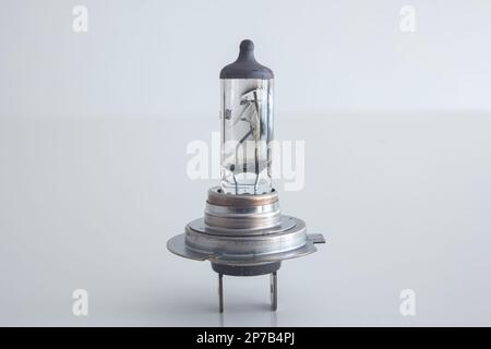 Gebrannte H7 12V 55W-Halogen-Autolampe. Nahaufnahme Studio, isoliert auf Weiß, keine Leute. Stockfoto