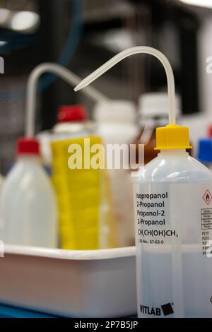 Isopropanol-Plastikflasche und Dispenser. Nahaufnahme in einem Labor. Geringe Schärfentiefe, keine Menschen. Stockfoto