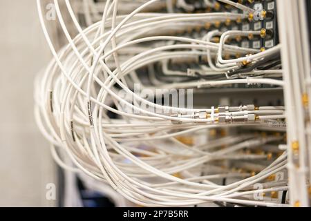 Elektronische Signalverarbeitungsgeräte in einem Wissenschaftslabor. Viele angeschlossene Kabel in Steckdosen. Organisiert, ordentlich, nicht chaotisch. Nahaufnahme, keine Leute Stockfoto