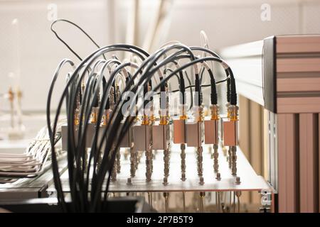 Elektronische Signalverarbeitungsgeräte in einem Wissenschaftslabor. Viele angeschlossene Kabel in Steckdosen. Organisiert, ordentlich, nicht chaotisch. Nahaufnahme, keine Leute. Stockfoto