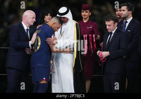 Gianni Infantino, Präsident der FIFA (links), und Katars Emir Sheikh Tamim bin Hamad al-Thani konsumieren Frankreichs Kylian Mbappe mit dem französischen Präsidenten Emmanuel Macron (rechts), nachdem Frankreich während des Finales der FIFA-Weltmeisterschaft im Lusail-Stadion in Katar die Niederlage gegen Argentinien abgeschossen hat. Foto: Sonntag, 18. Dezember 2022. Stockfoto