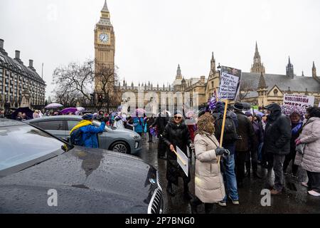 London, Großbritannien. 8. März 2023 Teilnehmer blockieren die Straße vor den Houses of Parliament während eines Protests gegen die Ungleichheit der staatlichen Rente (WASPI) auf dem Parliament Square am Internationalen Frauentag. Die Gruppe setzt sich weiterhin für Frauen ein, die in den 1950er Jahren geboren wurden und sich in finanziellen Schwierigkeiten befinden, nachdem das staatliche Renteneintrittsalter der Frauen durch das Gesetz von 1995 von 60 auf 65 Jahre angehoben wurde. Kredit: Stephen Chung / Alamy Live News Stockfoto