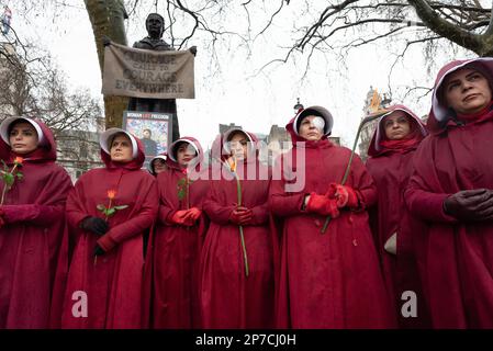 Parliament Square, London, Großbritannien. 8. März 2023 Britisch-iranische Frauen, gekleidet als Figuren aus der Geschichte der Magd, begehen den Internationalen Frauentag i. Stockfoto
