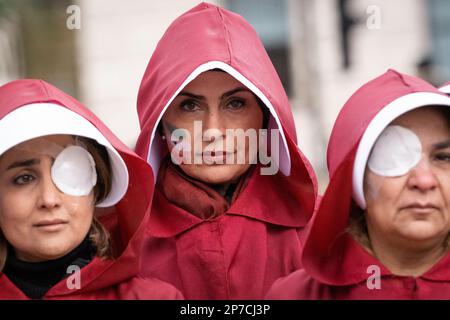 Parliament Square, London, Großbritannien. 8. März 2023 Britisch-iranische Frauen, gekleidet als Figuren aus der Geschichte der Magd, begehen den Internationalen Frauentag i. Stockfoto