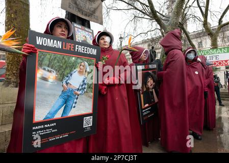 Parliament Square, London, Großbritannien. 8. März 2023 Britisch-iranische Frauen, gekleidet als Figuren aus der Geschichte der Magd, begehen den Internationalen Frauentag i. Stockfoto