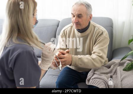 Verärgerter älterer Mann, der unterstützende Rede einer angenehmen Ärztin zuhört, Kopfschuss aus nächster Nähe. Mittelalter Sacharzt alter Patient Stockfoto