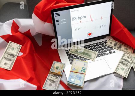 Laptop Gesundheit, Geld und kanada Flagge Stockfoto