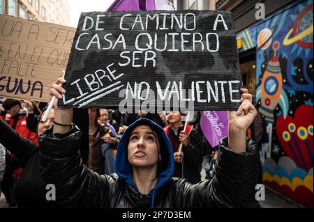 Madrid, Spanien. 08. März 2023. Eine Frau, die ein Plakat mit der Aufschrift "auf dem Weg nach Hause möchte ich frei sein, nicht mutig" trägt, wird während eines Protests gesehen, bei dem Studenten am Internationalen Frauentag demonstrieren, gleiche Rechte fordern und gegen geschlechtsspezifische Gewalt protestieren. Kredit: Marcos del Mazo/Alamy Live News Stockfoto