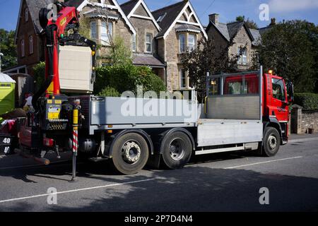 Ein Tieflader, der Baumaterialien auf eine Baustelle bringt. Stockfoto