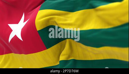 Togo-Nationalflagge winkt. Horizontale grüne und gelbe Streifen mit einem weißen Stern auf einem roten Quadrat in der oberen Ecke der Hebebühne. Strukturiertes Material auf der Rückseite Stockfoto