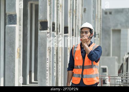 Männliche Ingenieure inspizieren und kontrollieren die Arbeit der Mitarbeiter und die Qualität der hergestellten Produkte, um die Standards in der Industrie zu erfüllen Stockfoto