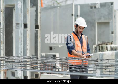 Männliche Ingenieure inspizieren und kontrollieren die Arbeit der Mitarbeiter und die Qualität der hergestellten Produkte, um die Standards in der Industrie zu erfüllen Stockfoto