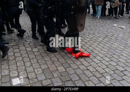 Frankreich / Paris / 07/03/2023, Jan Schmidt-Whitley/Le Pictorium - Demonstration gegen die Rentenreform in Paris - 7/3/2023 - Frankreich / Paris / Paris - Ein Polizist trampelt mit einer CGT-Flagge. Selbst wenn die Zahl der Streikenden nicht die Werte für Januar erreichte, begrüßten die Gewerkschaften am Dienstag, dem 7. März, eine "historische Mobilisierung" während der Demonstrationen, bei denen laut dem Innenministerium 1,28 Millionen Menschen in Frankreich und laut der CGT 3,5 Millionen Menschen zusammenkamen. Stockfoto