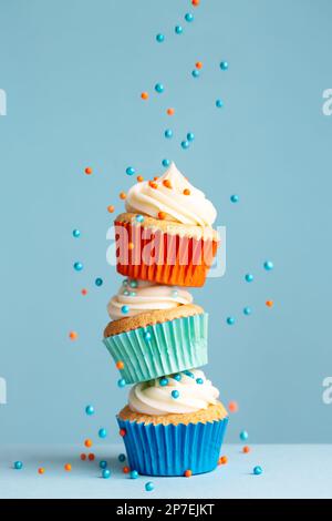 Zuckerstreusel fallen auf einen Stapel bunter Cupcakes Stockfoto