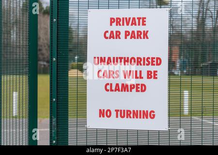 Schild: Privater Parkplatz, nicht autorisierte Autos werden festgeklemmt Stockfoto