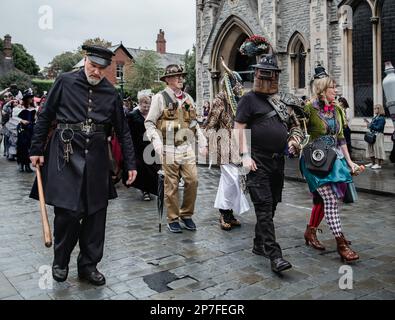 Eine Gruppe von Steampunken, die in einer Prozession entlang einer Straße laufen. Stockfoto