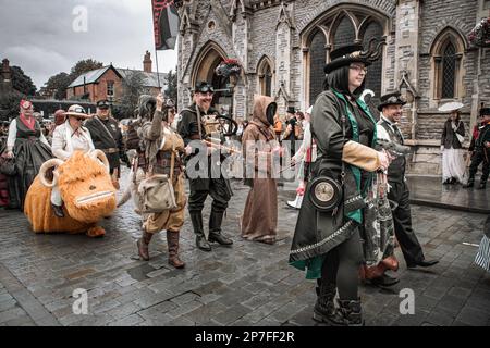 Eine Gruppe von Steampunken, die in einer Prozession entlang einer Straße laufen. Stockfoto