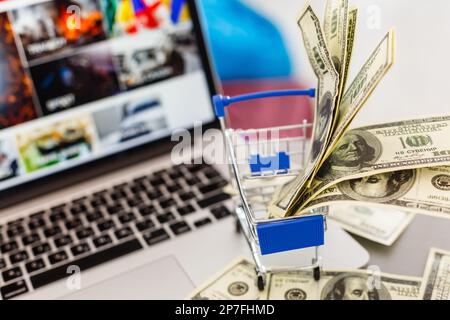 Ein Miniwagen aus einem Supermarkt steht auf einer Laptop-Tastatur. Austausch Stockfoto