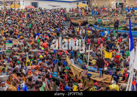 Blick von oben auf den belebten Fischereihafen und den Markt von elmina ghana Hunderte von Arbeitern, die traditionelle Holzboote auf den Markt laden Stockfoto