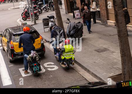 Barcelona, Spanien-Februar 22,2023: Eltern transportieren ihre Kinder auf maßgeschneiderten E-Bikes Stockfoto