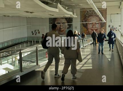 Passagiere, die an einer Collage ihrer verstorbenen Majestät Queen Elizabeth II. Vorbeikommen, am Flughafen Gatwick, England, Großbritannien Stockfoto