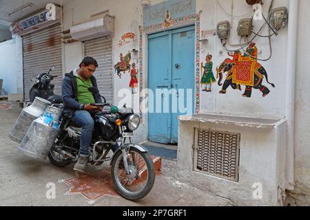 UDAIPUR, INDIEN, 5. November 2017 : Milch wird mit dem Motorrad an die Häuser von Udaipur geliefert. Stockfoto