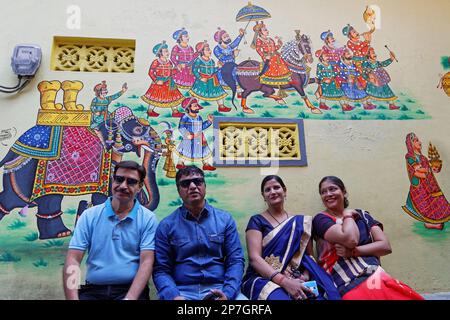 UDAIPUR, INDIEN, 5. November 2017 : Porträt einer indischen Familie vor ihrem bemalten Haus in einer kleinen Straße der Stadt. Stockfoto