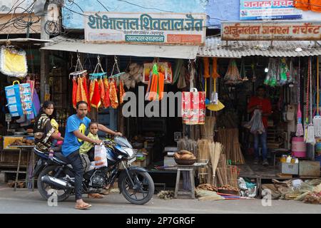 UDAIPUR, Indien, 5. November 2017: eine Familie beginnt auf einem Motorrad vor einem kleinen Laden, der traditionelle Markt in Udaipur, Rajasthan. Stockfoto