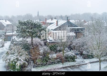 Blick auf Häuser und Gärten in einem Vorort während des unerwarteten späten Schneeschauers im März 2023, Mariakerke, Gent, Ostflandern, Belgien Stockfoto